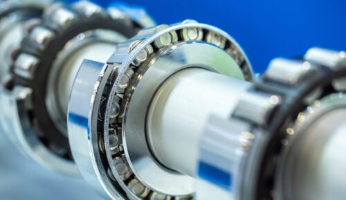 Four tapered roller bearings installed on a shaft. Their cups have been cut away to show the internal elements of the roller bearing.